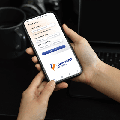 Close-up, a female hands holding smartphone Yoma Car Share Find a car screen
